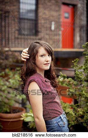 Stock Photograph - Teenage girl standing on urban rooftop. Fotosearch