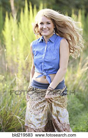 Teenage girl walking in tall grass View Large Photo Image Stock Image - Teenage girl walking in tall grass. Fotosearch