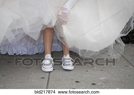 Picture - Teenage girl wearing sneakers under quinceanera dress. Fotosearch