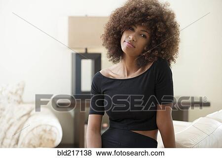 Stock Photo - Teenage girl with curly hair indoors. Fotosearch