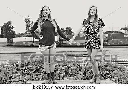Teenage girls holding hands in train yard View Large Photo Image Stock Photo - Teenage girls holding hands in train yard. Fotosearch