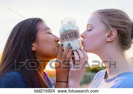 Teenage girls kissing adventure savings jar View Large Photo Image Picture - Teenage girls kissing adventure savings jar. Fotosearch