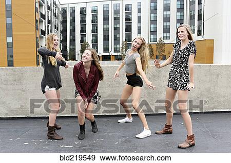Teenage girls posing on urban rooftop View Large Photo Image Stock Photo - Teenage girls posing on urban rooftop. Fotosearch