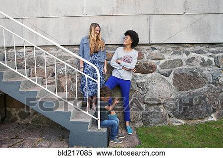 Teenagers and boy standing on steps View Large Photo Image Stock Photography - Teenagers and boy standing on steps. Fotosearch