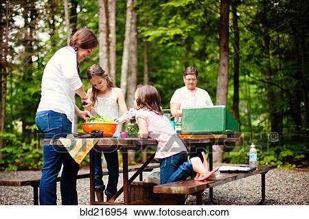 Three generations of Caucasian women cooking at picnic table View Large Photo Image Picture - Three generations of Caucasian women cooking at picnic table. Fotosearch