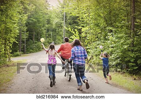 Picture - Three generations of Caucasian women walking on dirt road. Fotosearch