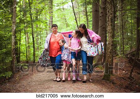 Stock Photography - Three generations of Caucasian women walking in forest. Fotosearch