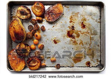 Stock Image - Tray of roasted pears and fruit. Fotosearch