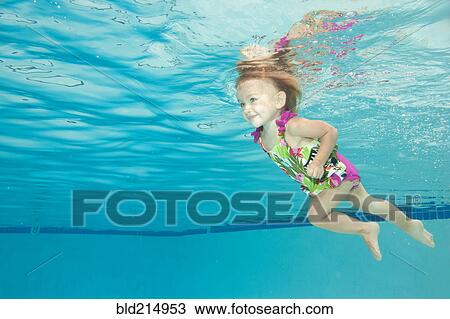 Stock Image - Underwater view of Caucasian girl swimming in pool. Fotosearch
