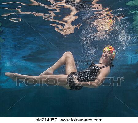 Stock Photo - Underwater view of Caucasian woman posing in swimming pool. Fotosearch
