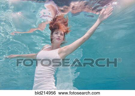 Underwater view of mixed race woman in dress swimming in pool View Large Photo Image Stock Photograph - Underwater view of mixed race woman in dress swimming in pool. Fotosearch