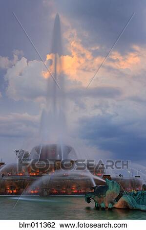 Stock Image - Urban fountain spraying water at night. Fotosearch