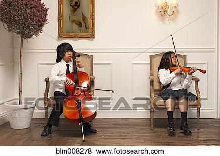 Stock Photo - Vietnamese children with musical instruments sitting on elegant chairs. Fotosearch