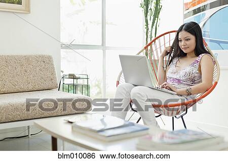 Vietnamese woman using laptop in living room View Large Photo Image Stock Photograph - Vietnamese woman using laptop in living room. Fotosearch
