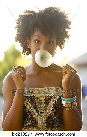 Woman blowing bubble gum bubble outdoors View Large Photo Image Stock Photo - Woman blowing bubble gum bubble outdoors. Fotosearch