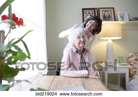 Picture - Woman combing hair of elderly mother. Fotosearch