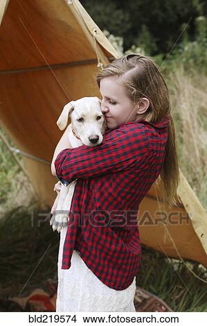 Picture - Woman cuddling dog near camping tent. Fotosearch