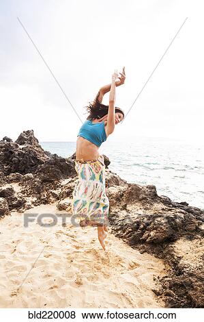 Woman dancing on rocky beach View Large Photo Image Stock Photo - Woman dancing on rocky beach. Fotosearch