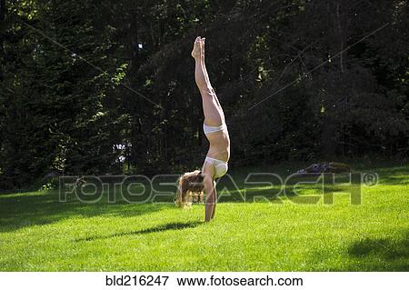 Woman doing handstand in backyard View Large Photo Image Stock Photo - Woman doing handstand in backyard. Fotosearch