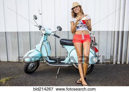 Woman eating shave ice near scooter View Large Photo Image Stock Photo - Woman eating shave ice near scooter. Fotosearch