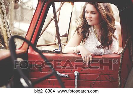 Picture - Woman examining vintage truck interior. Fotosearch