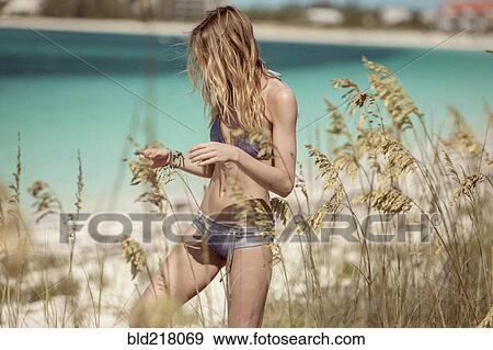 Woman in bikini walking in beach grass View Large Photo Image Stock Photo - Woman in bikini walking in beach grass. Fotosearch