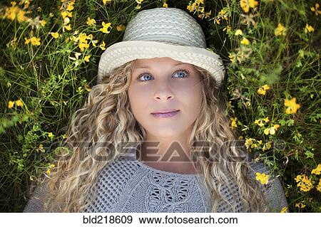 Woman in straw hat laying in flowers View Large Photo Image Stock Photo - Woman in straw hat laying in flowers. Fotosearch