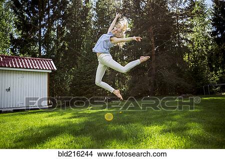 Woman jumping for joy in backyard View Large Photo Image Picture - Woman jumping for joy in backyard. Fotosearch