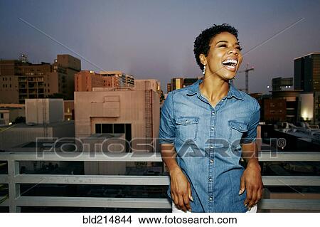 Woman laughing on urban rooftop View Large Photo Image Picture - Woman laughing on urban rooftop. Fotosearch