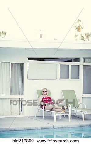 Woman laying on lawn chair near swimming pool View Large Photo Image Stock Photo - Woman laying on lawn chair near swimming pool. Fotosearch