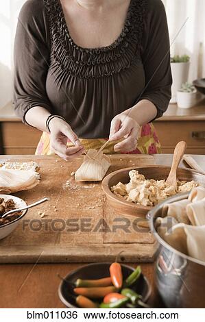 Stock Photograph - Woman making tamales. Fotosearch