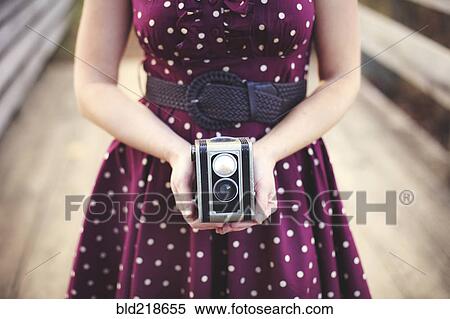 Stock Photography - Woman photographing with vintage camera. Fotosearch