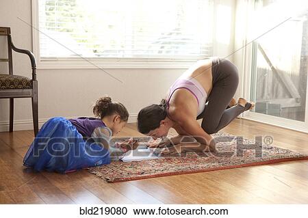 Woman practicing yoga and helping daughter with homework View Large Photo Image Stock Image - Woman practicing yoga and helping daughter with homework. Fotosearch