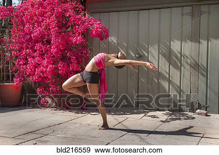 Woman practicing yoga near flowers and fence View Large Photo Image Stock Photo - Woman practicing yoga near flowers and fence. Fotosearch