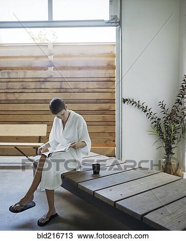 Stock Image - Woman reading magazine in spa. Fotosearch