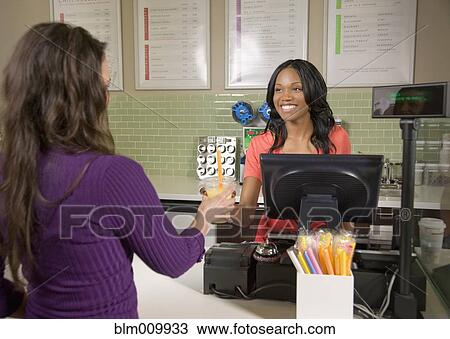 Stock Image - Woman serving customer bubble tea in cafe. Fotosearch