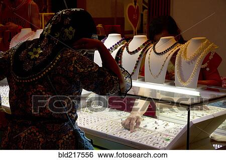 Woman shopping for jewelry in store View Large Photo Image Stock Photograph - Woman shopping for jewelry in store. Fotosearch