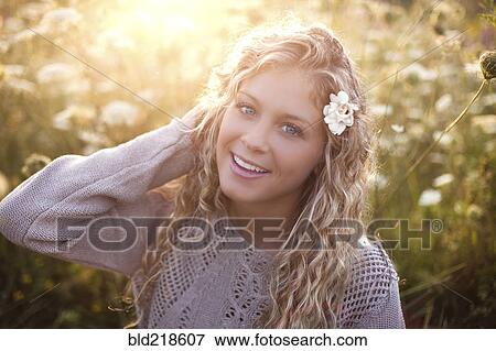 Stock Photo - Woman sitting in tall flowers. Fotosearch