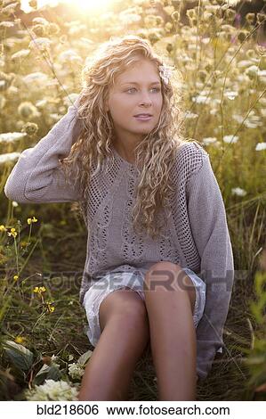 Woman sitting in tall flowers View Large Photo Image Stock Photograph - Woman sitting in tall flowers. Fotosearch