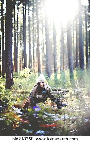 Woman sitting on log in forest View Large Photo Image Stock Photo - Woman sitting on log in forest. Fotosearch