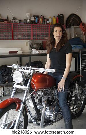 Woman sitting on motorcycle in garage View Large Photo Image Stock Photography - Woman sitting on motorcycle in garage. Fotosearch