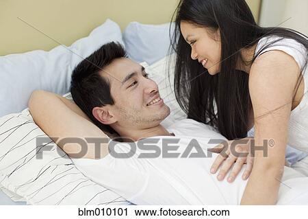 Woman smiling at husband in bed View Large Photo Image Stock Image - Woman smiling at husband in bed. Fotosearch