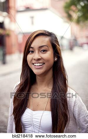 Stock Photo - Woman smiling on city sidewalk. Fotosearch