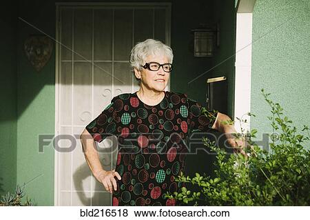 Woman standing at door View Large Photo Image Stock Photo - Woman standing at door. Fotosearch