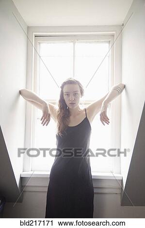 Woman standing at sunny window View Large Photo Image Stock Image - Woman standing at sunny window. Fotosearch