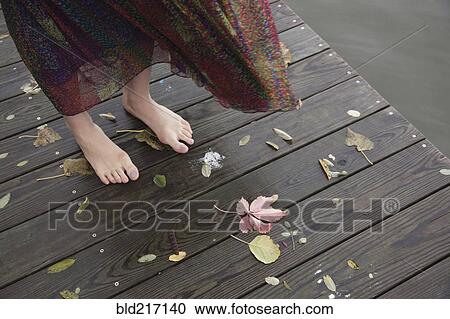 Woman standing barefoot on wooden dock View Large Photo Image Stock Image - Woman standing barefoot on wooden dock. Fotosearch