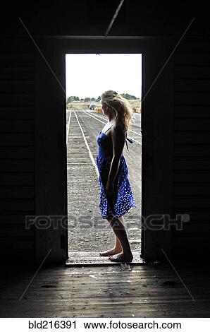 Woman standing in doorway of train in train yard View Large Photo Image Stock Image - Woman standing in doorway of train in train yard. Fotosearch