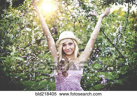 Stock Photography - Woman standing in flowering trees. Fotosearch