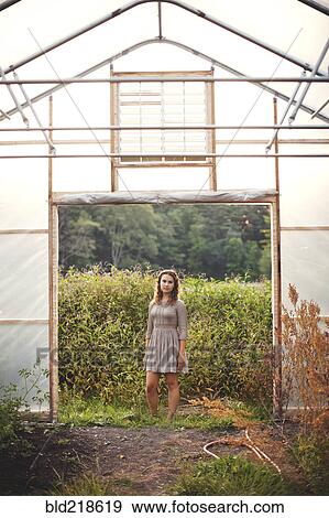 Woman standing in greenhouse doorway View Large Photo Image Stock Photo - Woman standing in greenhouse doorway. Fotosearch