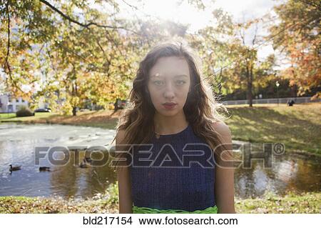 Woman standing near duck pond in park View Large Photo Image Picture - Woman standing near duck pond in park. Fotosearch